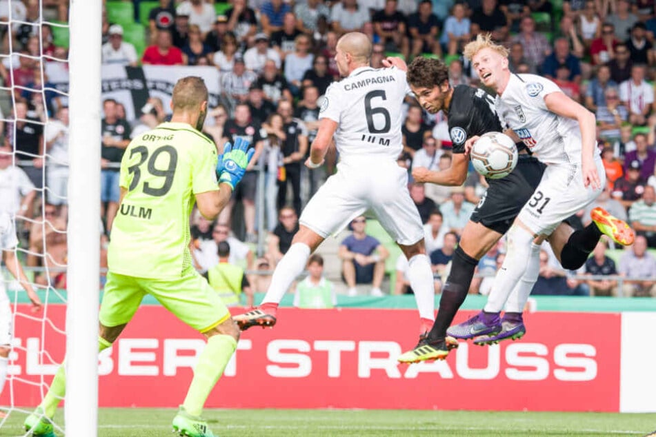 Ulms Christian Ortag (l-r), Luigi Campagna, Frankfurts Lucas Torro und Ulms Nico Gutjahr kämpfen vor dem Ulmer Tor um den Ball.