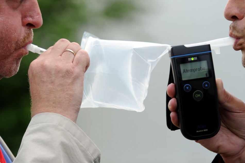 Seit Jahrzehnten wird der Atemalkoholgehalt durch Pusten ermittelt, allerdings in modernen Geräten (rechts) und noch nicht mit Smartphones (Symbolbild).