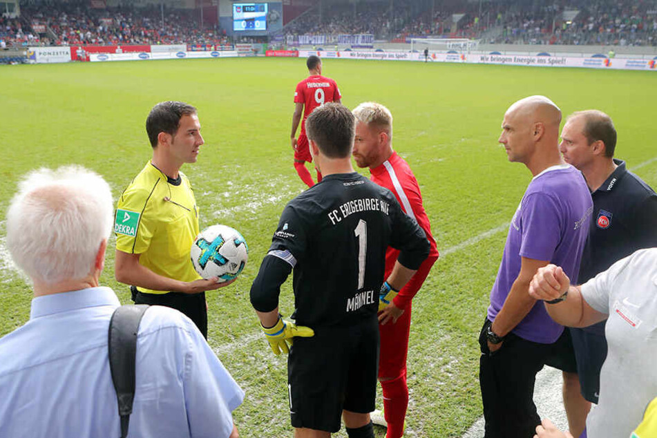 Schiedsrichter Benjamin Brand unterbricht die Partie und ruft die Kapitäne Martin Männel (schwarzes Trikot) und Marc Schnatterer (rechts daneben) zu sich.