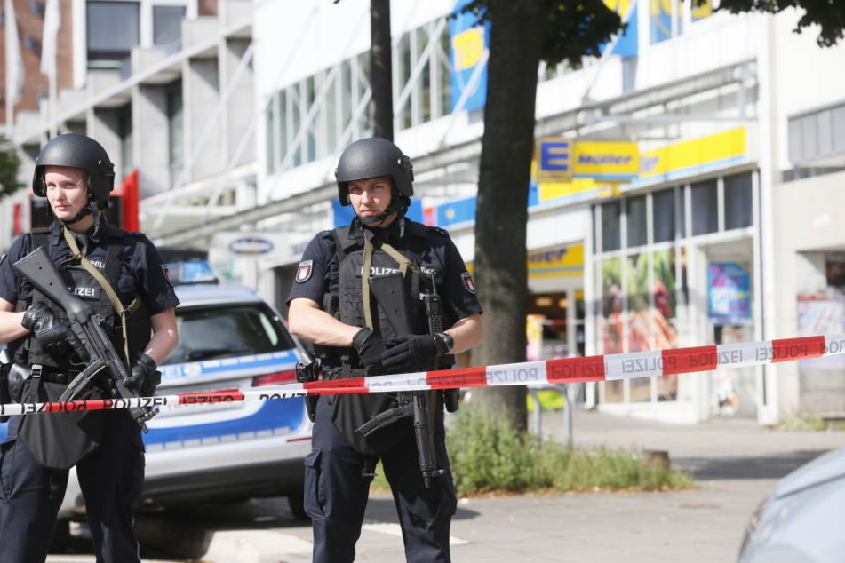 Einsatzkräfte der Polizei sperren nach der Messerattacke in Hamburg den Tatort ab.