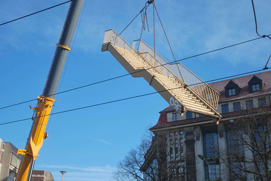Mithilfe eines Krans wird die Brücke Stück für Stück abgetragen.