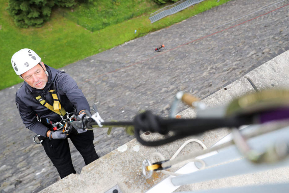 Thorsten Lermer (54), Chef einer Chemnitzer Firma für Höhenarbeit, seilt sich
an der Staumauer der Talsperre Werda ab, entfernt Laub, Moos, Gräser und
Baumsprösslinge aus den Fugen.