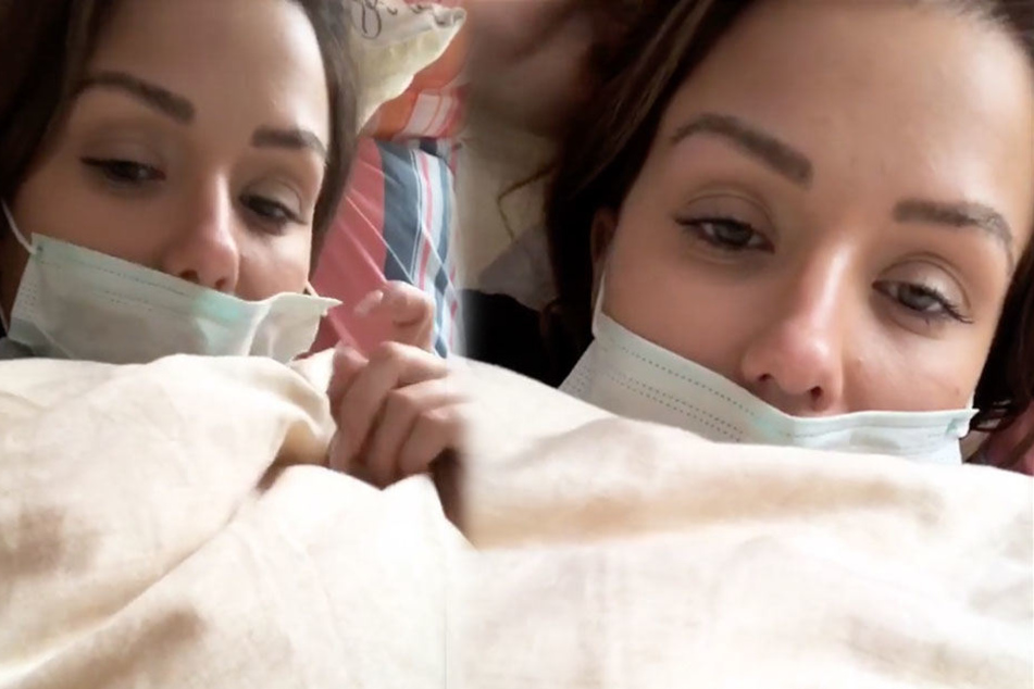 Kim Gloss mit Mundschutz im Bett. Die Sängerin leidet an Scharlach.