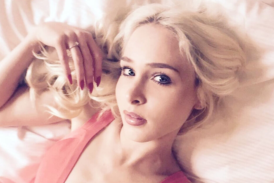 Theresia macht von sich im Bett liegend ein Selfie.