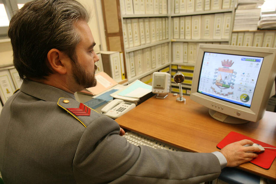 Ein Polizist der italienischen Guardia di Finanza (Finanzpolizei) sitzt vor einem Computer und prüft Steuererklärungen.