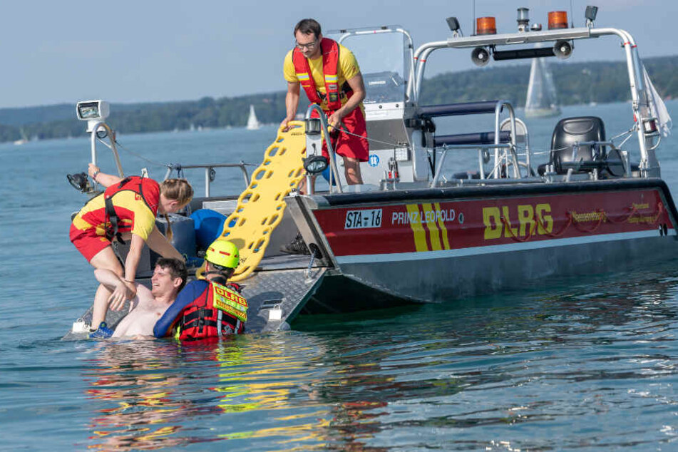 Rettungsschwimmer ziehen bei einer Übung einen "ertrinkenden" Mann aus dem Wasser.