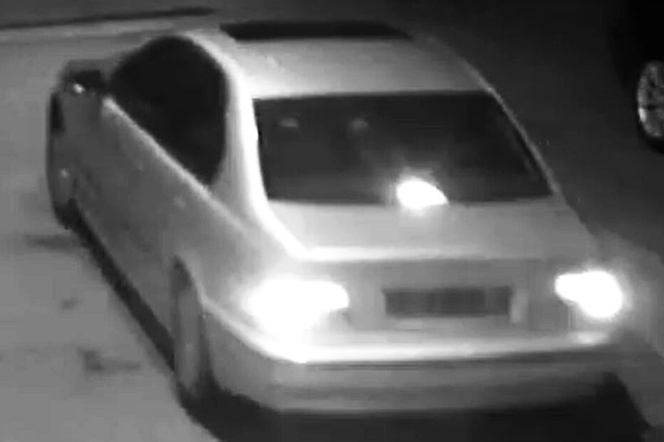 Der Fluchtwagen der beiden Räuber, ein silberner BMW der 5er-Reihe, hat ein schwarzes Schiebedach und eine rote Bremsleuchte in der Mitte der Heckscheibe.