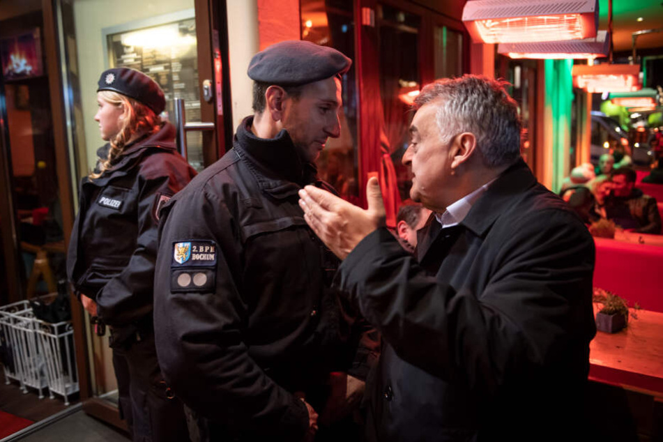 Innenminister Herbert Reul unterhält sich während der Razzia von Zoll und Polizei in einer Shisha-Bar mit einem Polizisten.