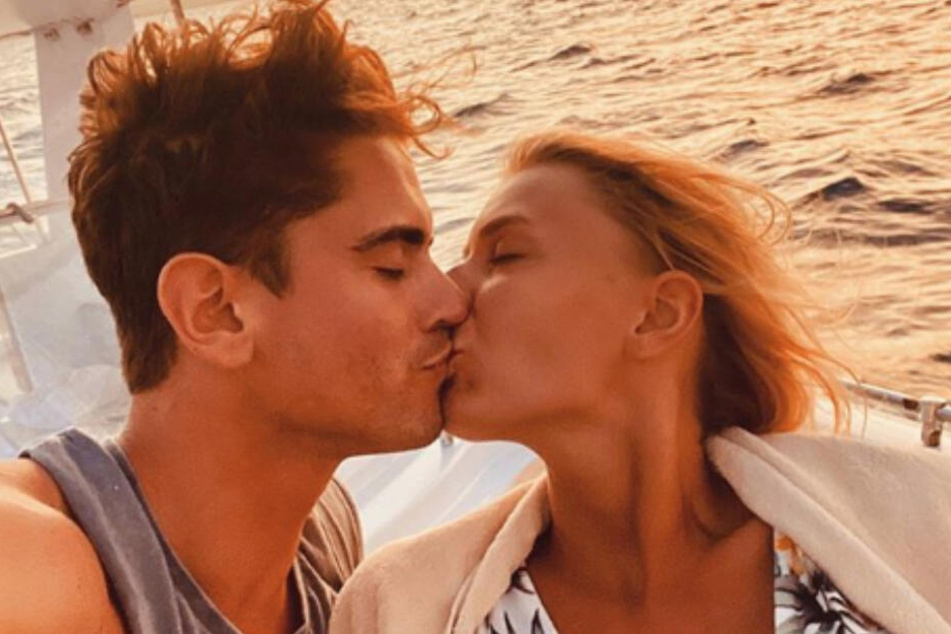 Jolina und Dominik küssen sich im gemeinsamen Urlaub.