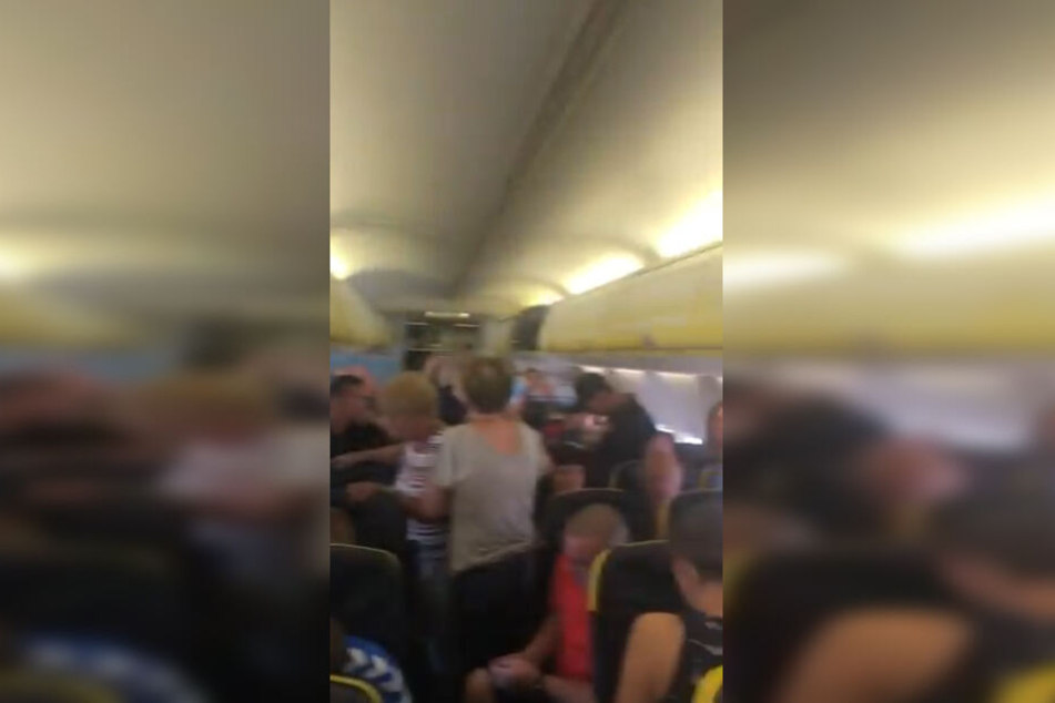 Die Passagiere stehen hilflos auf dem Flugzeuggang.
