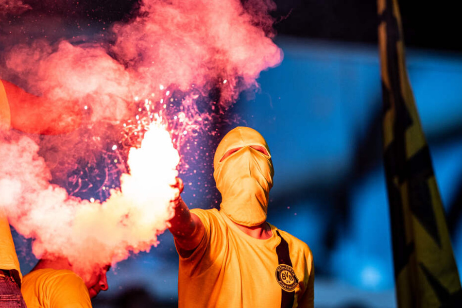 Ein vermummter BVB-Anhänger, der beim Revierderby am 9. Spieltag ein bengalisches Feuer abgebrannt hat.