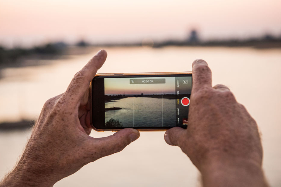 Mit einem Handy filmte der Unbekannte das kleine Mädchen beim Spielen in einem kleinen Fluss. (Symbolbild)