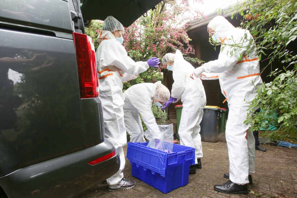 In weißen Schutzanzügen machen sich Ermittler der Mordkommission bereit, den Tatort zu untersuchen.