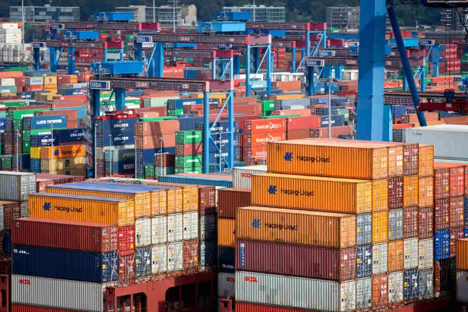 Ein hoch mit Containern beladene Containerschiff der Reederei Hapag-Lloyd liegt am Terminal Burchardkai im Hafen von Hamburg.