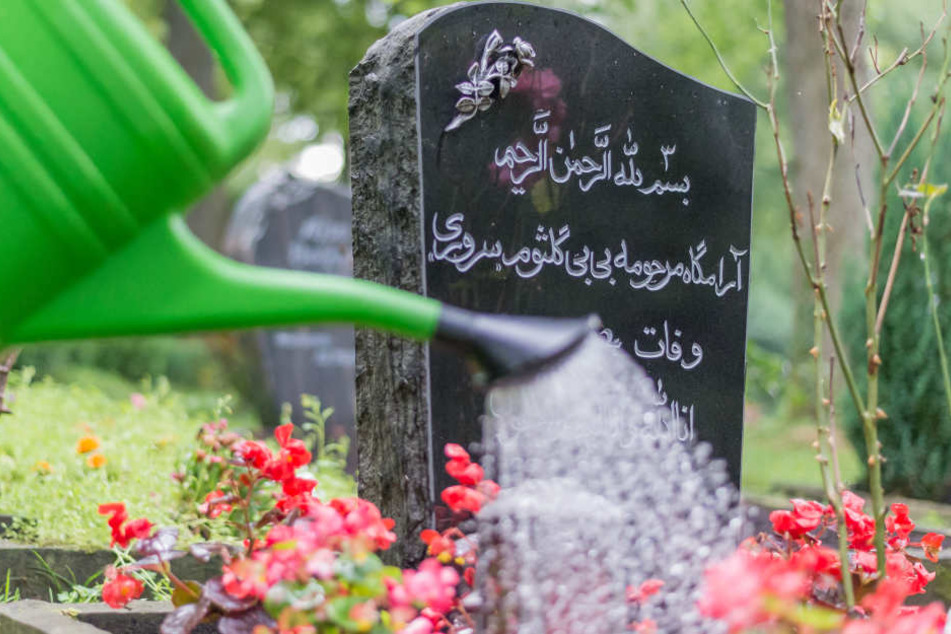 Ein Grabstein eines Muslimen ist mit Blumen geschmückt.