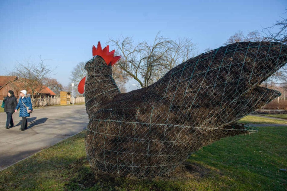 Besucher gehen auf der ega in Erfurt (Thüringen) an einer Hühnerfigur aus Erde und Metallgitter vorbei, die derzeit unbepflanzt ist.