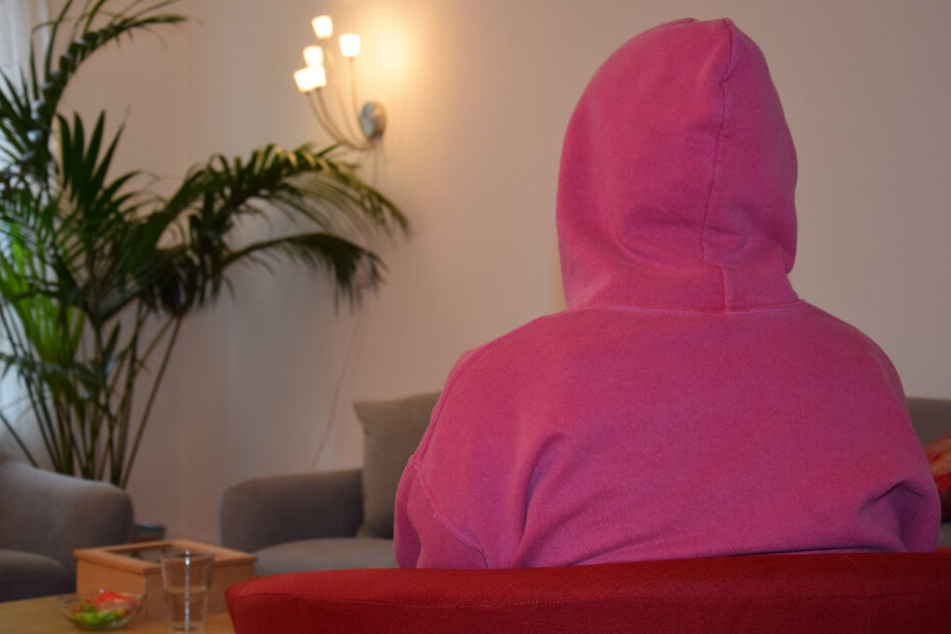 Alessia sitzt mit einem Kapuzenpullover auf einem Sessel in der Beratungsstelle YASEMIN.