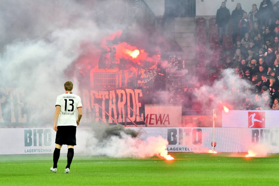 (Leider) schon fast gewohntes Bild: Die Eintracht-Fans warfen vor dem Anpfiff mit Pyrotechnik umher. Frankfurts Martin Hinteregger (Li.) betrachtet das unschöne Spektakel.