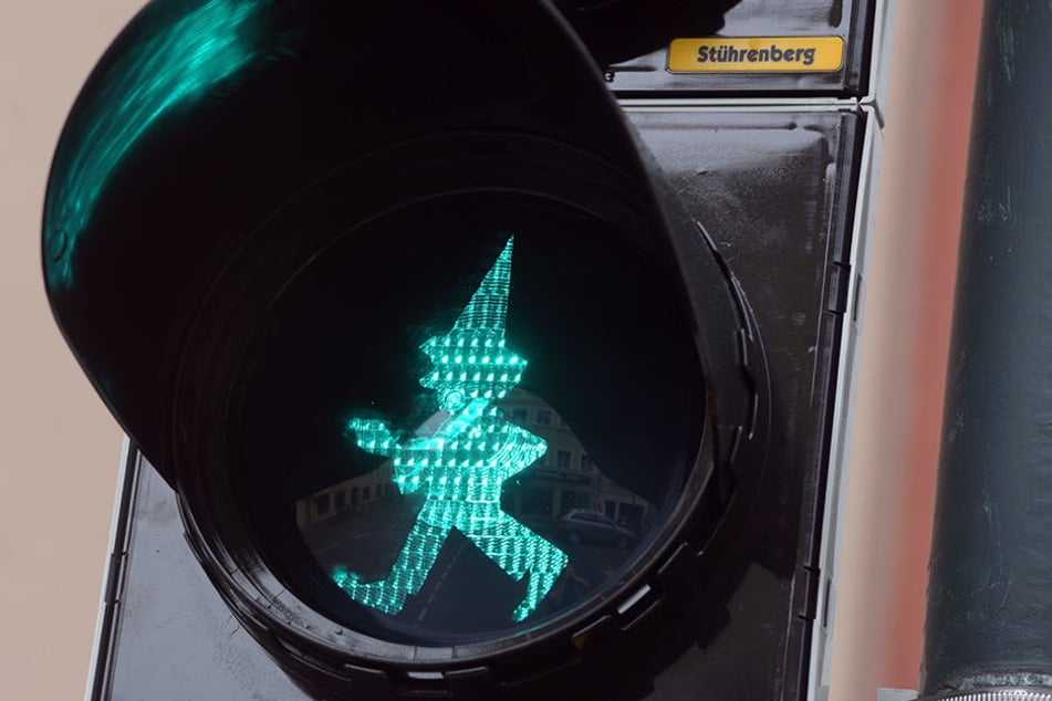 An einer Ampel leuchtet in Augsburg die Silhouette des Kasperl.