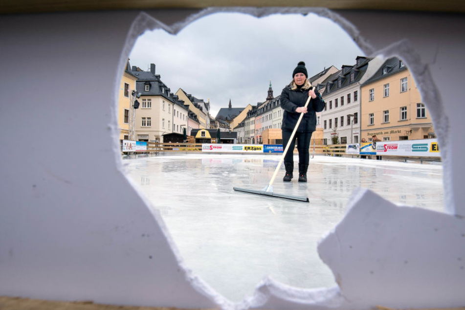 Auch an der Bande klaffen Löcher. Steffi Heidel (58) von den Stadtwerken entfernt Glassplitter vom Eis.