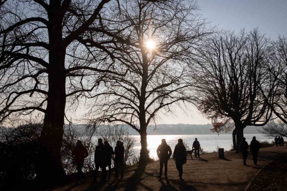 Bei milden Temperaturen spazieren die Menschen an der Außenalster entlang.