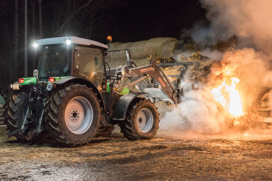 Mit Hilfe des Traktors wurden die brennenden Strohballen auseinandergezogen und schließlich abgelöscht.