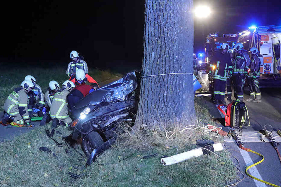 Retter kümmern sich um dem Mann, der nach dem schweren Unfall in seinem Auto eingeklemmt ist.