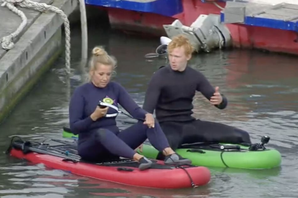 Die Moderatorin erhält von ihrem Surflehrer noch kurze Anweisungen.