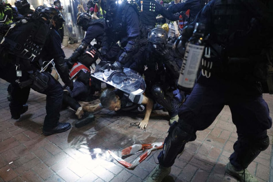 Polizisten drücken Teilnehmer einer Kundgebung gegen Polizeigewalt auf den Boden. (Archivbild)
