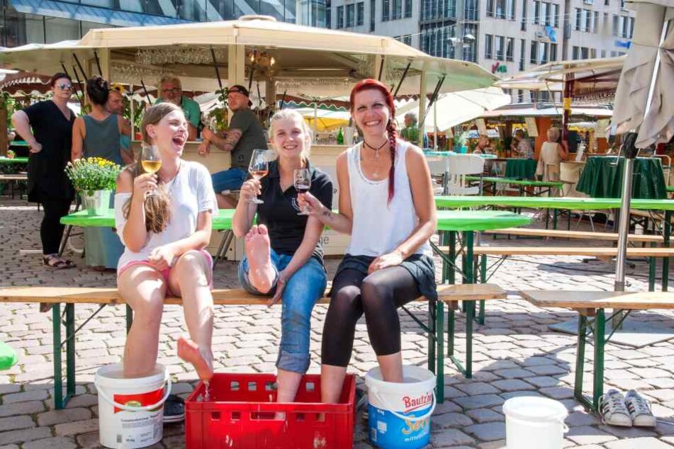 Kara Alvina Enzian (16),
Annekatrin Rades (28) und
Nancy Enzian (34) kühlen
sich auf dem Weindorf mit
kaltem Wasser ab.