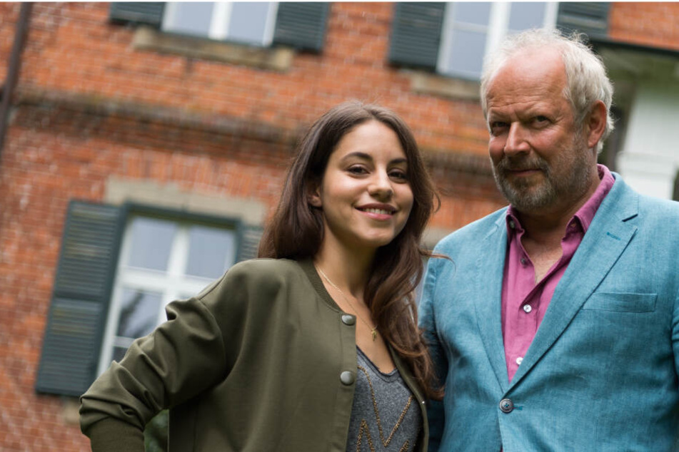 Die Schauspieler Almila Bagriacik (links) und Axel Milberg stehen vor einem der Drehorte für den aktuellen Tatort im schleswig-holsteinischen Niendorf.