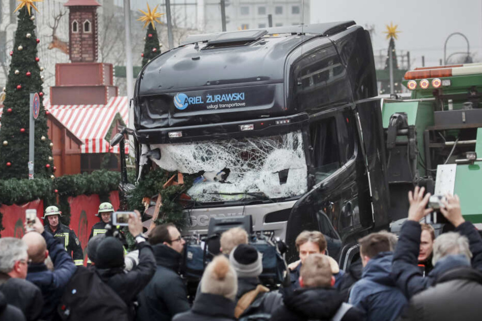 Schaulustige und Reporter stehen vor dem LKW mit dem ein Anschlag auf den Weihnachtsmarkt verübt worden war. (Archivbild)