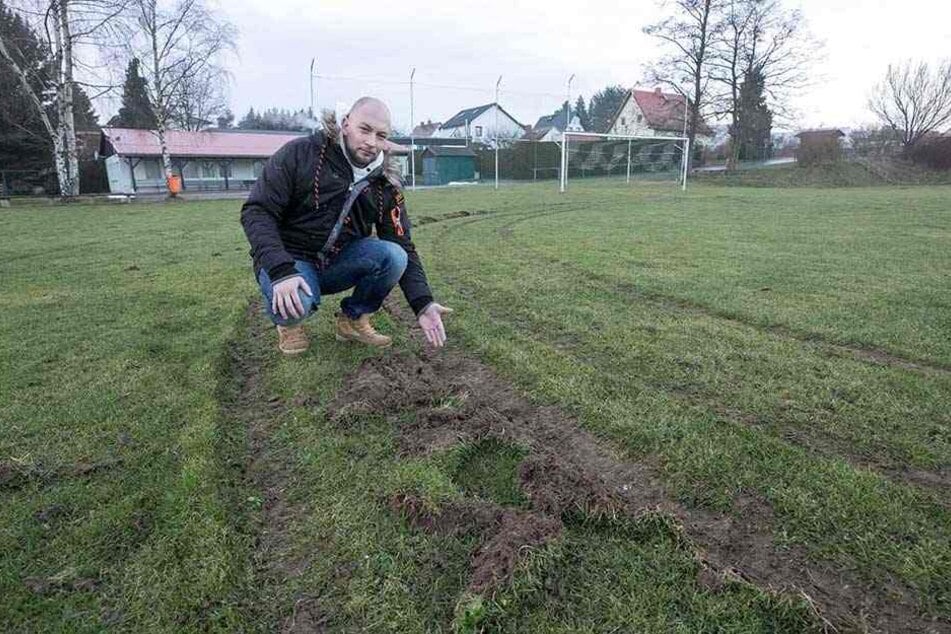 Fußball-Chef Martin Urban (31) zeigt den verwüsteten Rasen auf dem Spielplatz.
