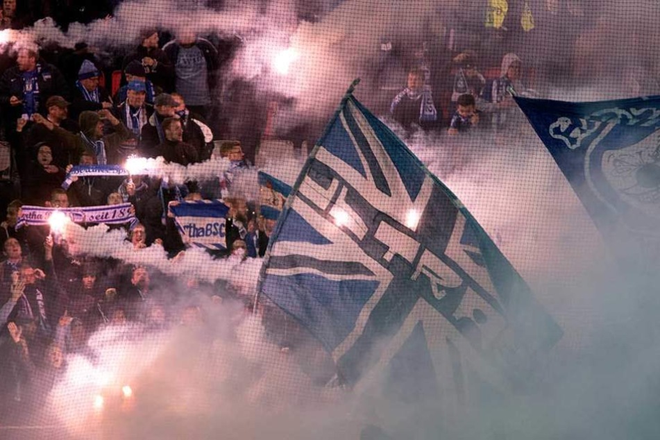 Mitgereiste Fans von Hertha BSC brennen Pyro im Gästeblock ab.