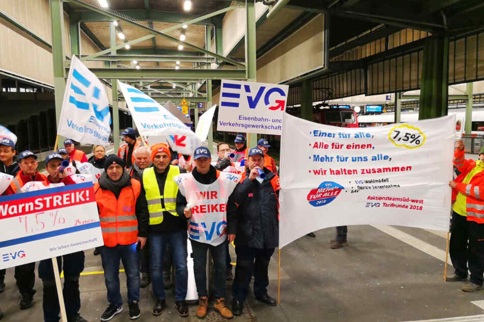 Streikende stehen am Stuttgarter Hauptbahnhof.