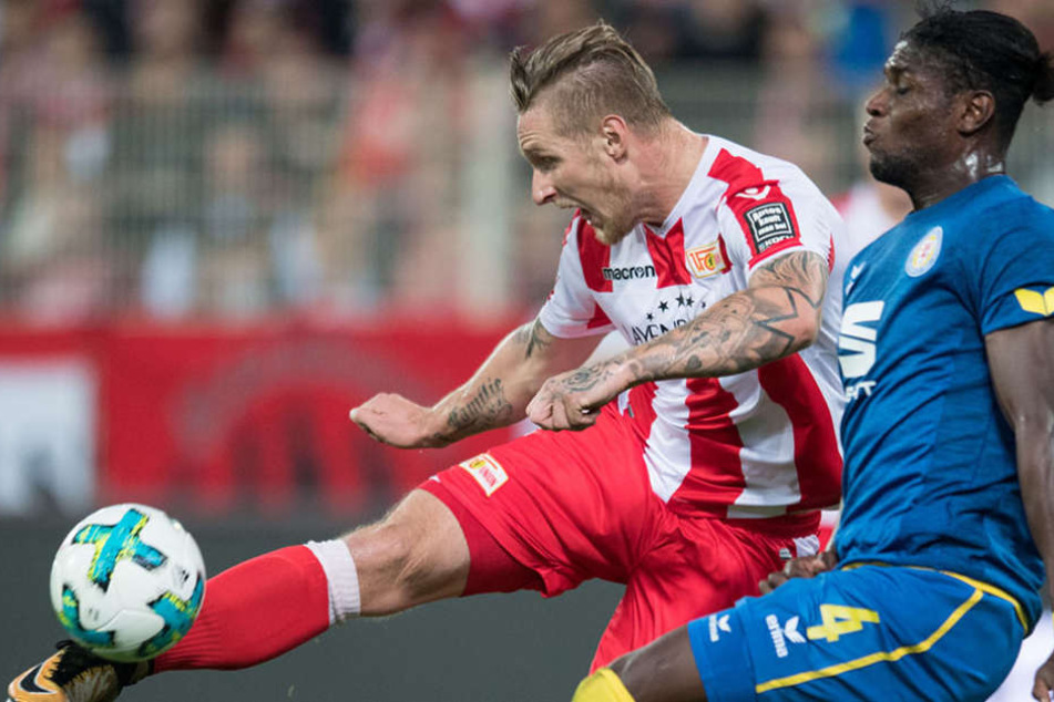 Unions Sebastian Polter schießt den Ball gegen Braunschweigs Joseph Baffo (r).