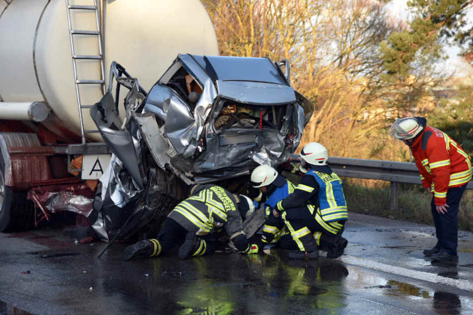 Rettungskräfte arbeiten am Montag unter einem der Autos, die von einem Sattelzug erfasst wurden.