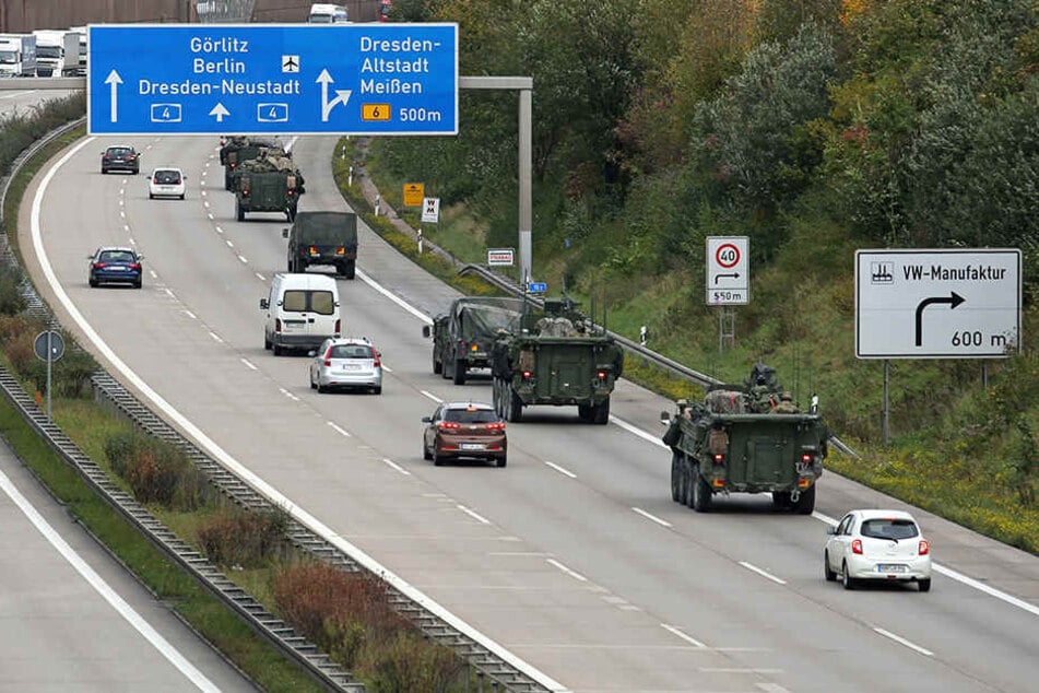 Von ungläubigen Blicken verfolgt, bewegt sich ein Konvoi der US-Army über die Autobahn.