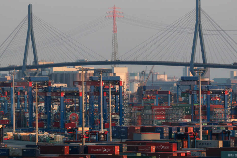 Container stehen am Containerterminal Burchardkai auf dem Gelände der HHLA, im Hintergrund ist die Köhlbrandbrücke zu sehen.
