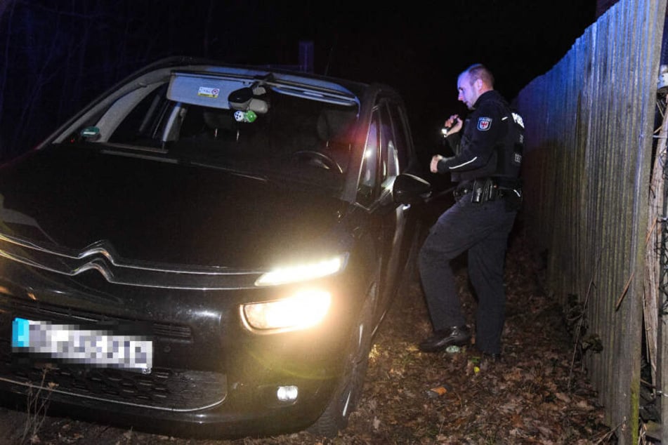 Ein Polizist untersucht den gestohlenen Wagen.