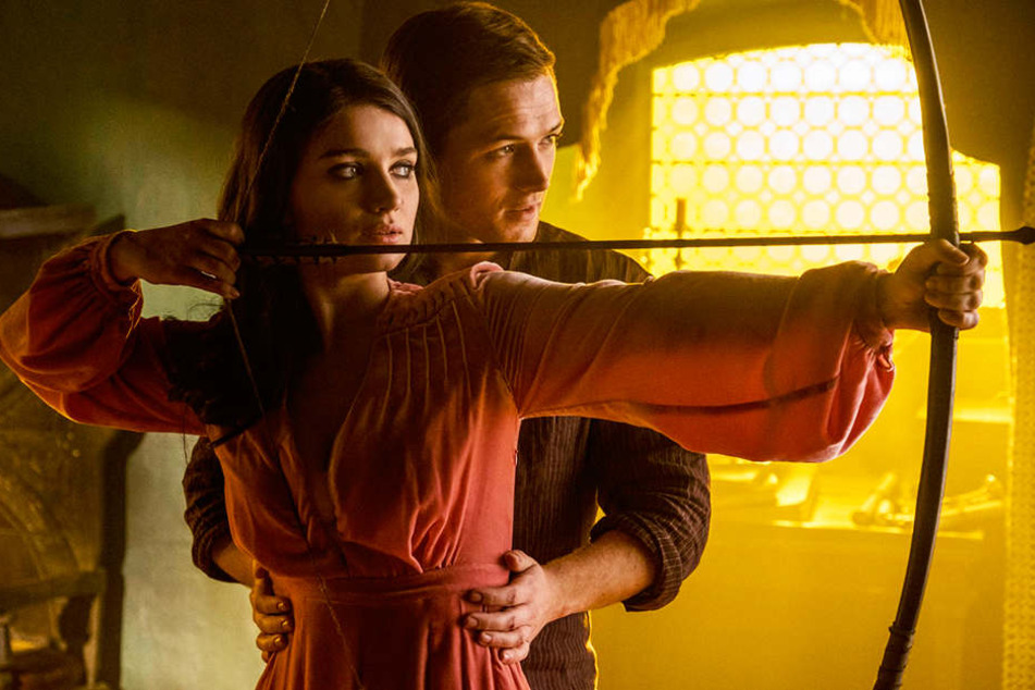 Jungfrau Marian (vorne; Eve Hewson) und Robin von Loxley (Taron Egerton) lernen sich früh kennen und lieben.