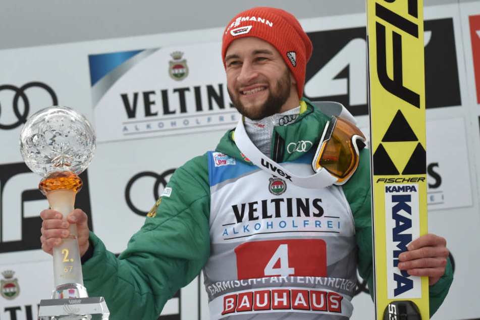 Markus Eisenbichler jubelt mit Pokal bei der Siegerehrung.