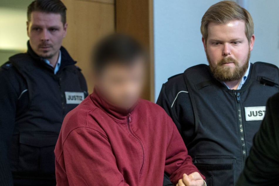 Der angeklagte Lastwagenfahrer aus Rumänien wird von einem Justizmitarbeiter in den Sitzungssaal des Landgerichtes in Freiburg gebracht.
