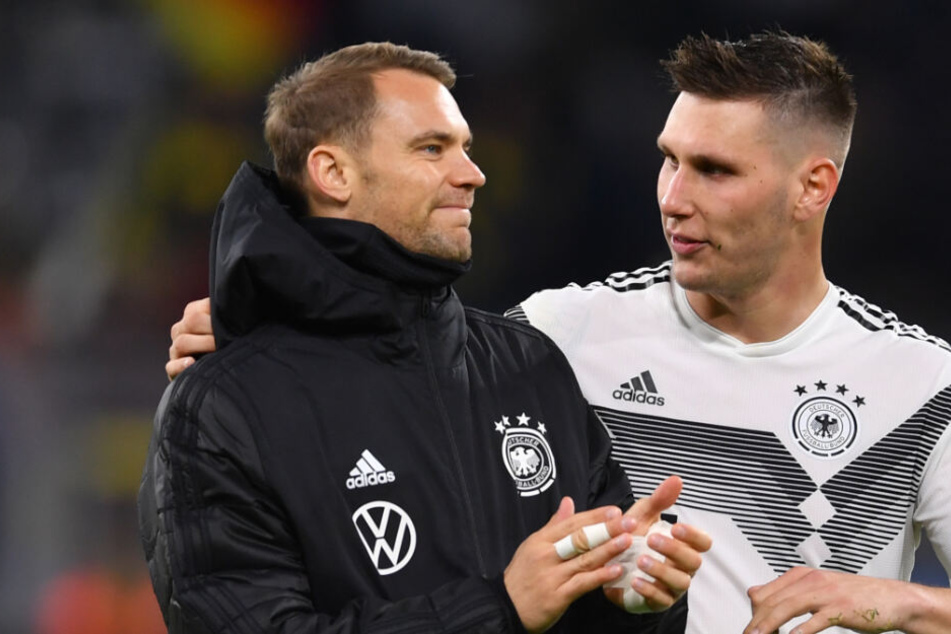 Niklas Süle (r) und Torhüter Manuel Neuer reden nach einem Länderspiel.