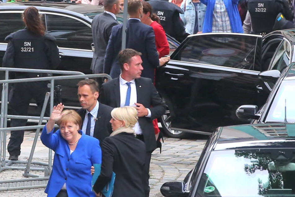 Gut bewacht, grüßt Angela Merkel (64, CDU) beim Dresden-Aufenthalt in die Menge.