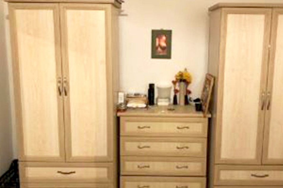 Links ein Schrank, rechts ein Schrank, in der Mitte eine Kommode. Doch witzigerweise ist im Spiegel über den Möbeln die Oberweite einer Frau zu sehen.