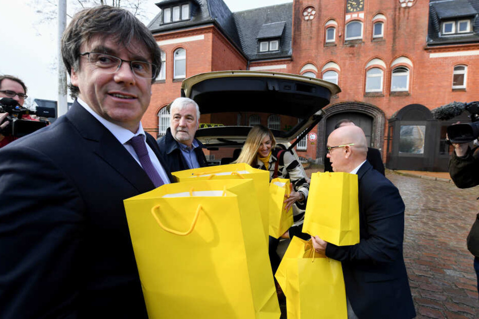 Der katalanischer Separatistenführer Carles Puigdemont hält vor der JVA gelbe Tüten in der Hand. Er brachte 100 Bücher katalanischer Autoren in deutscher Übersetzung für die Gefängnisbibliothek mit.