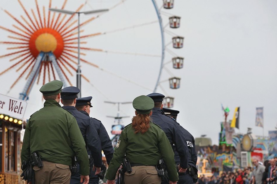 Auftakt zum Oktoberfest am 16.September in München (Bayern). Polizisten stehen vor dem Riesenrad.