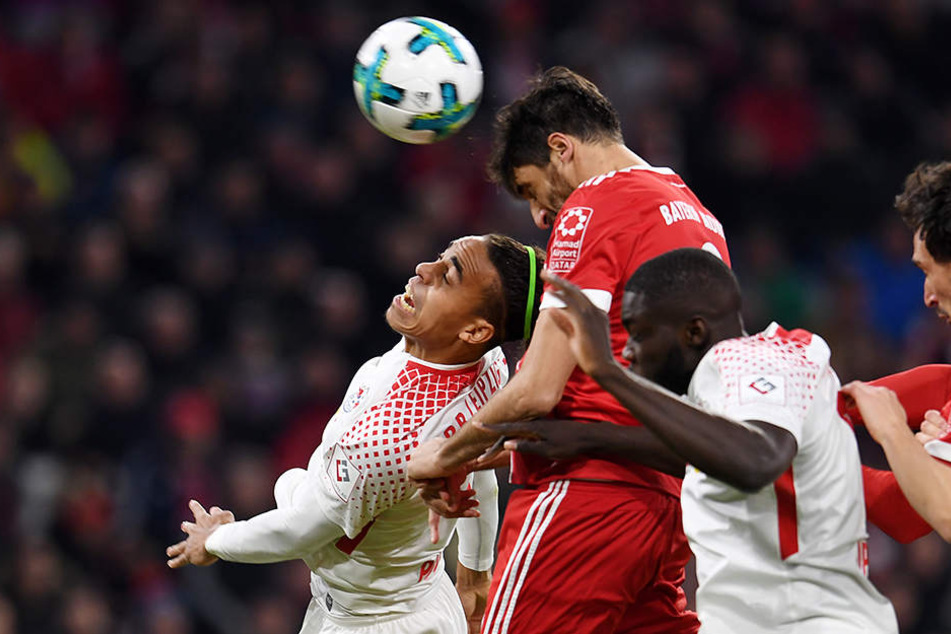 Yussuf Poulsen (l.) von Leipzig, Javier Martinez (m.) von Bayern und Dayot Upamecano (r.) von RB Leipzig kämpfen um den Ball.
