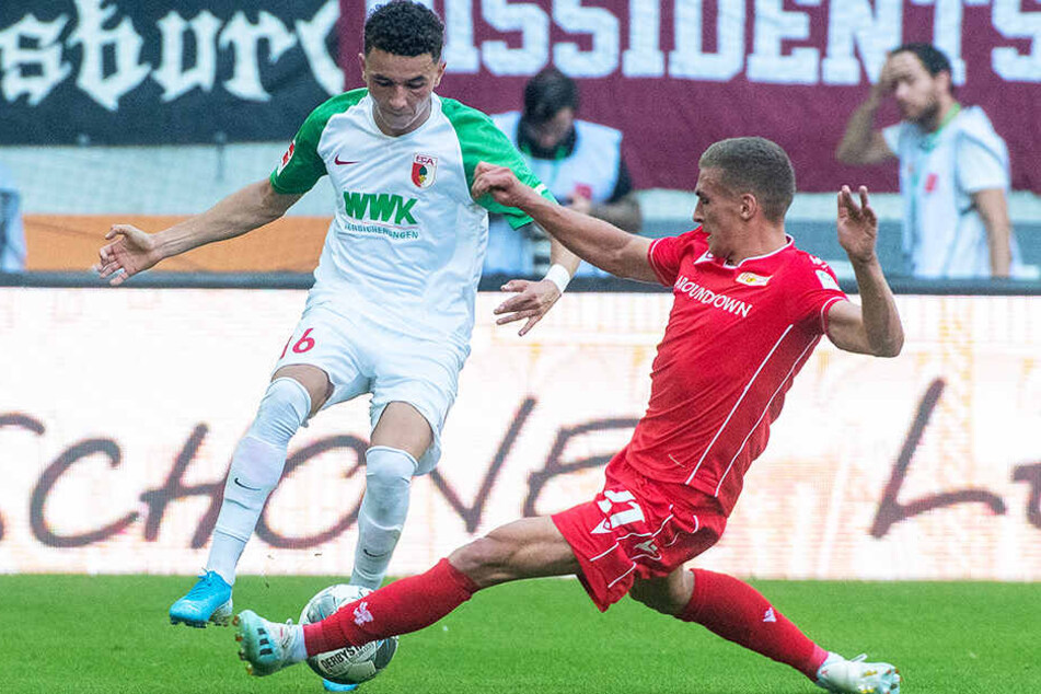 Augsburgs Torschütze Ruben Vargas wird hier von Unions Grischa Prömel (r.) abgegrätscht.